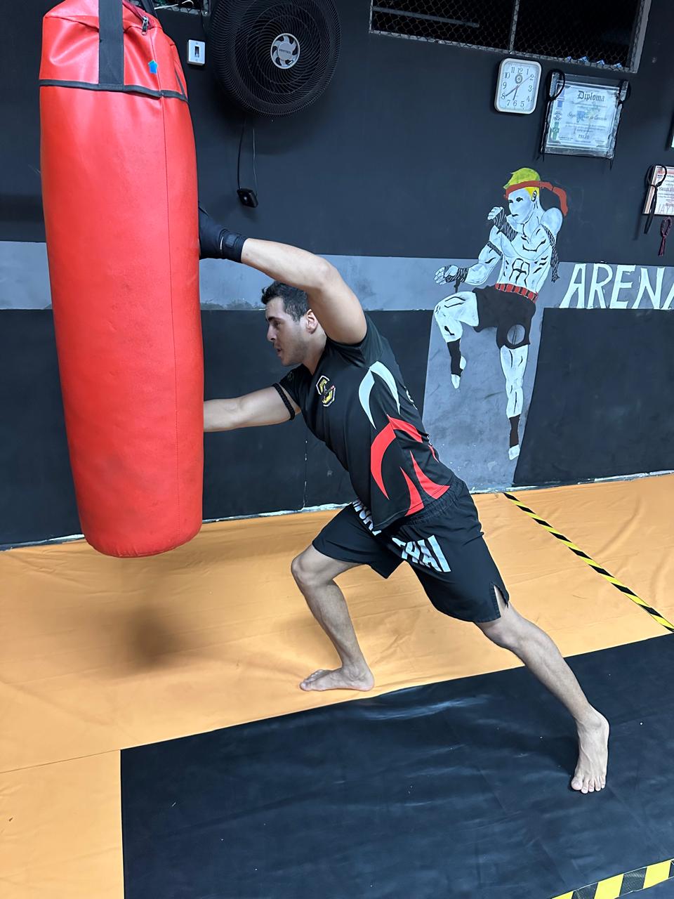 Professor treinando golpes no saco de pancadas