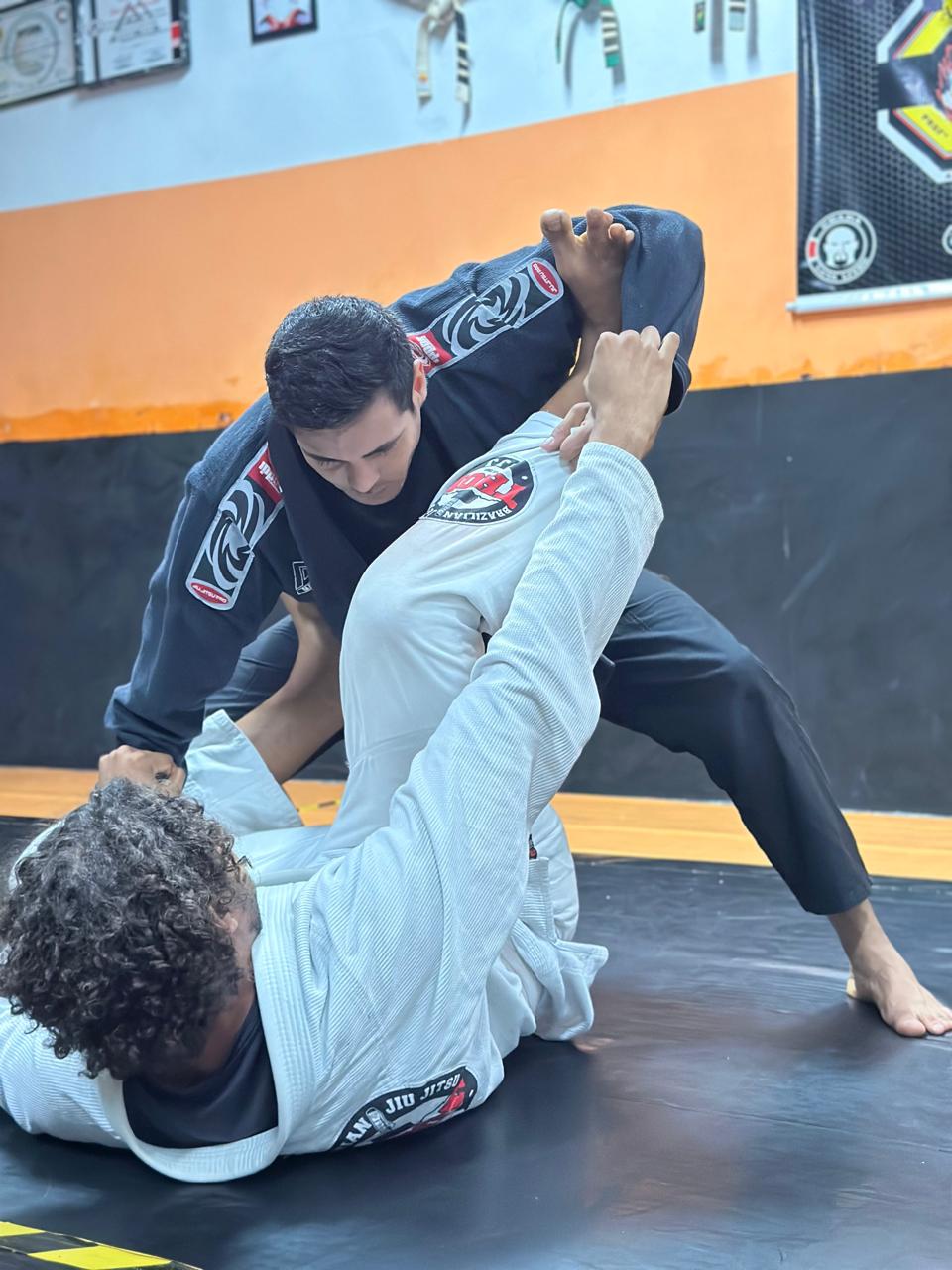 Professor demonstrando técnica de Jiu-Jitsu com aluno